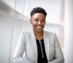 Confident African American businesswoman smiling inside a modern office space.